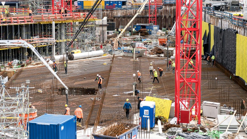 A bustling construction site in Hamburg with workers and equipment actively engaged in building tasks.